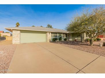 House exterior featuring a light green single story home with a two car garage and a neatly landscaped yard at 12734 W Crystal Lake Dr, Sun City West, AZ 85375