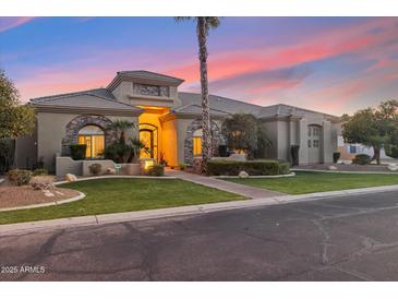 Inviting single-story home boasts desert landscaping, arched entryway and windows and beautiful desert sunset at 2625 N 24Th St # 36, Mesa, AZ 85213