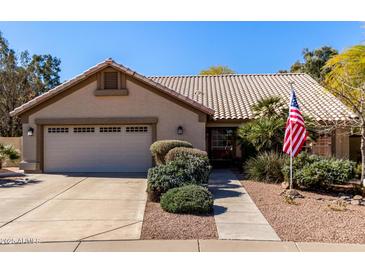 Charming single-story home featuring a tile roof, lush landscaping, and a two-car garage at 5373 W Dublin Ct, Chandler, AZ 85226