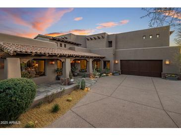 Expansive desert home featuring a tile roof, well-manicured landscaping, and a spacious driveway leading to a large garage at 9290 E Thompson Peak Pkwy # 444, Scottsdale, AZ 85255