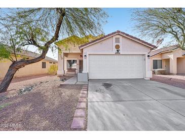 Single-story home with a two-car garage and landscaped front yard at 14885 W Caribbean Ln, Surprise, AZ 85379