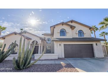 Charming two-story home showcasing a well-manicured yard, neutral tones, and an attached two-car garage at 15857 N 51St Pl, Scottsdale, AZ 85254