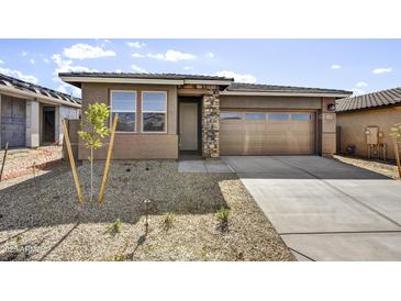 Charming single-story home featuring a stone-accented facade, gravel landscaping, and a two-car garage at 17299 W Desert Sage Dr, Goodyear, AZ 85338