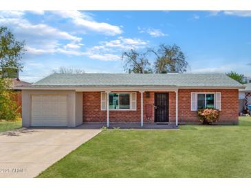 Brick ranch house with attached garage and well-maintained lawn at 2317 W W Whitton Ave Ave, Phoenix, AZ 85015