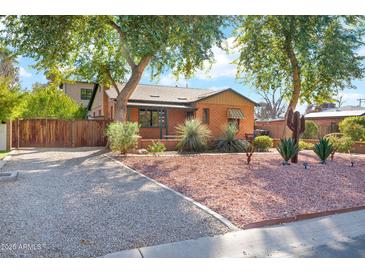 Charming brick home with mature trees and desert landscaping for excellent curb appeal at 311 W Georgia Ave, Phoenix, AZ 85013