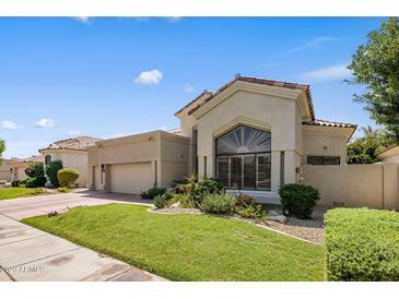 Tan two-story home with a tile roof, landscaping, and a two-car garage at 7439 E Beryl Ave, Scottsdale, AZ 85258