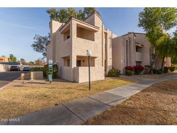 Two-story condo building with a walkway and landscaping at 7510 E Thomas Rd # 234, Scottsdale, AZ 85251