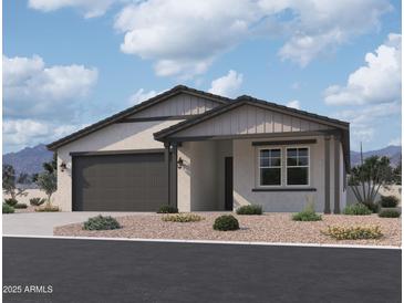 One-story home with gray siding, dark gray garage door, and landscaping at 9534 W Luxton Ln, Tolleson, AZ 85353