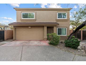 Tan two-story house with a two-car garage and desert landscaping at 15550 N Frank Lloyd Wright Blvd # 1009, Scottsdale, AZ 85260