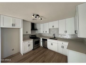 Newly renovated kitchen, featuring white shaker cabinets, stainless steel appliances, and modern backsplash at 2227 W Paradise Dr, Phoenix, AZ 85029