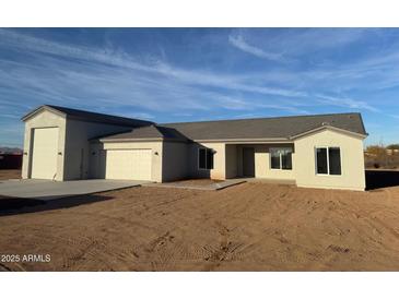 New construction home with a two-car garage and desert landscaping at 28304 N 220Th Ave, Wittmann, AZ 85361