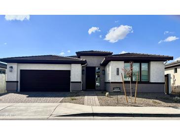 Single-story home with a two-car garage and landscaped front yard at 39190 N Kaden Ln, San Tan Valley, AZ 85140