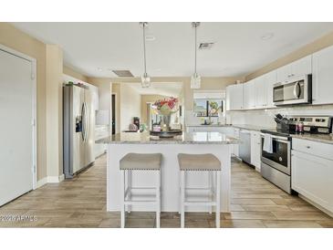 Modern kitchen with white cabinets, granite countertops, and stainless steel appliances at 730 W El Alba Way, Chandler, AZ 85225