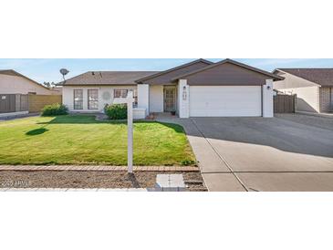 Charming single-story home with a well-manicured lawn, white brick accents and a two car garage at 7331 W Aster Dr, Peoria, AZ 85381