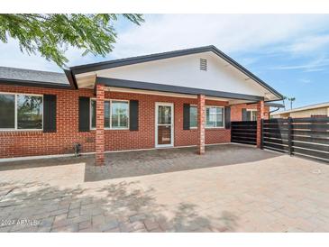 Brick home with modern fence and landscaped yard at 7725 E Portland St, Scottsdale, AZ 85257