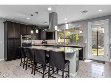 Modern kitchen boasts granite counters, stainless steel appliances, and a large island with bar stool seating at 10129 E Ampere Ave, Mesa, AZ 85212