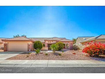 Charming single-story home featuring a well-maintained front yard, desert landscaping, and a two-car garage at 16331 W Willow Creek Ln, Surprise, AZ 85374