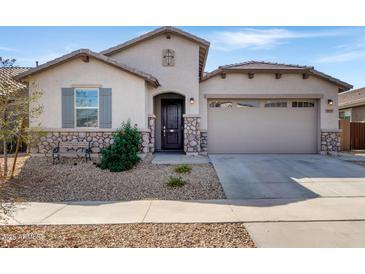 Charming single-Gathering home featuring stone accents, desert landscaping, and a two-car garage at 18819 W Cholla St, Surprise, AZ 85388