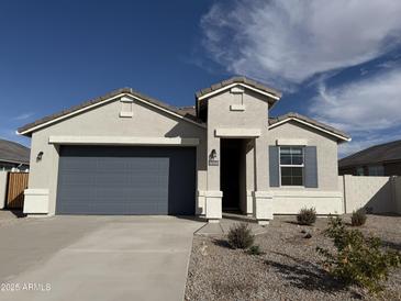 One-story home with gray garage door and landscaping at 36060 W San Ildefanso Ave, Maricopa, AZ 85138