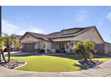 Charming single-story home featuring a well-manicured lawn and a desert-friendly landscape with healthy palm trees at 8171 W Beaubien Dr, Peoria, AZ 85382