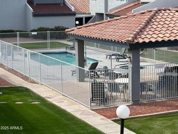 Community pool and covered seating area with tables and lounge chairs for relaxing at 220 N 22Nd Pl # 2059, Mesa, AZ 85213