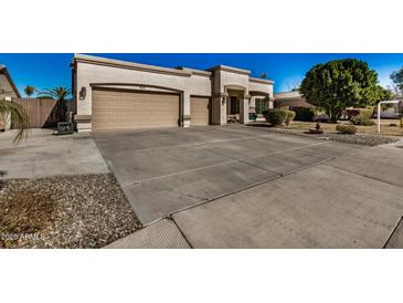 Charming home showcasing a three car garage and low-maintenance desert landscaping at 3036 E Boston St, Gilbert, AZ 85295