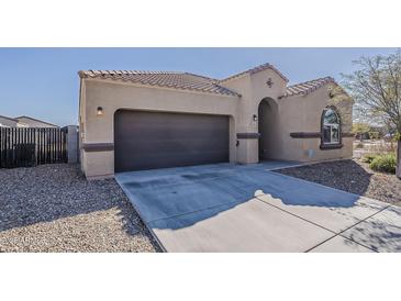 Inviting single-story home featuring a two-car garage, neutral color palette, and tile roof, perfect for modern living at 1203 E Judi St, Casa Grande, AZ 85122