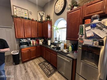 A traditional kitchen features wood cabinets and a large clock above the window at 14440 N 56Th Pl, Scottsdale, AZ 85254