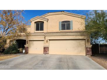 Charming two-story home featuring a two-car garage and classic desert landscape at 23000 W Kimberly Dr, Buckeye, AZ 85326