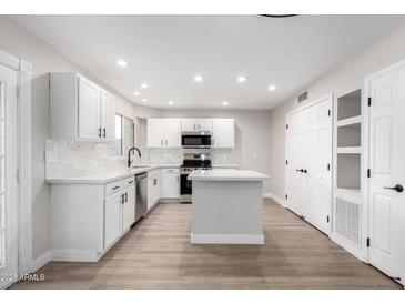 Modern kitchen with white cabinets, quartz countertops, and stainless steel appliances at 4432 E Belleview St, Phoenix, AZ 85008