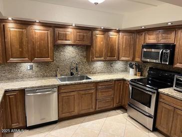 Gourmet kitchen featuring granite countertops, stainless steel appliances, and custom cabinetry at 5132 N 31St Way # 112, Phoenix, AZ 85016