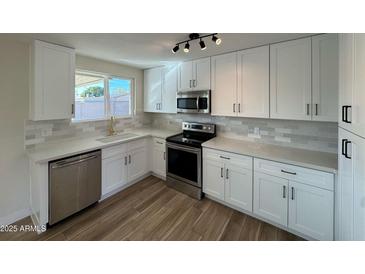 Remodeled kitchen features white cabinets, stainless steel appliances, and quartz countertops at 5313 W Osborn Rd, Phoenix, AZ 85031