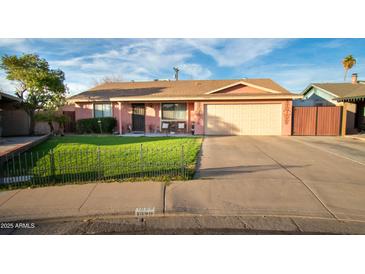 Cute ranch home with a well-manicured lawn and a two-car garage at 1028 E Emerald Ave, Mesa, AZ 85204