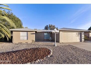 Tan house with a two-car garage and landscaped front yard at 26622 S Beech Creek Dr, Sun Lakes, AZ 85248