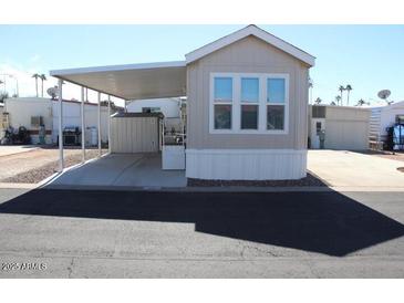 Tan mobile home with carport and storage shed at 306 S Recker Rd # 80S, Mesa, AZ 85206