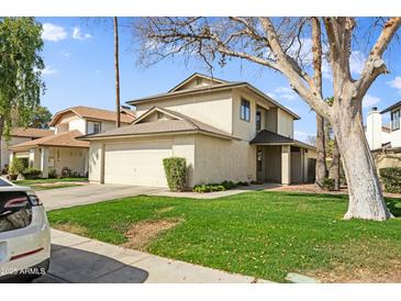 Two-story house with attached garage and grassy front yard at 10024 W Montecito Ave, Phoenix, AZ 85037