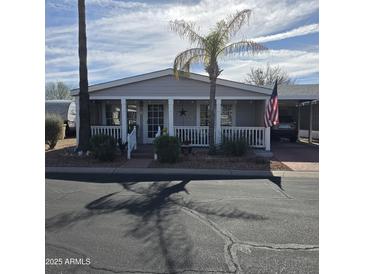 Charming single-story home with a covered front porch, well-maintained landscaping and covered parking at 11411 N 91St Ave # 225, Peoria, AZ 85345