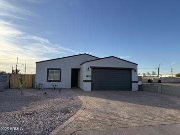 New construction home with gray garage door and landscaped front yard at 1238 S 14Th St, Phoenix, AZ 85034
