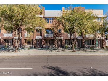 Exterior street view of townhomes with a modern design, trees, and well-maintained landscaping at 6605 N 93Rd Ave # 1101, Glendale, AZ 85305