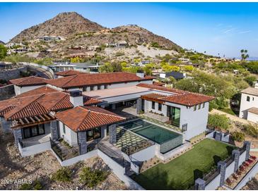Luxury home featuring a pool, well-manicured lawn, and a stunning mountain view backdrop at 6825 N 39Th Pl, Paradise Valley, AZ 85253