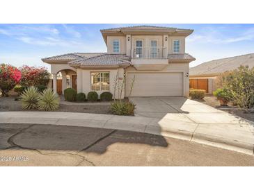 Two-story house with a tan stucco exterior, tile roof, and landscaped yard at 10765 N 119Th St, Scottsdale, AZ 85259