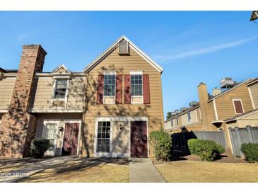 Front view of charming townhome with brick chimney and maroon doors at 18621 N 34Th Ave # 1, Phoenix, AZ 85027