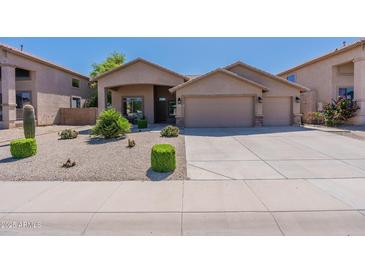 Beautiful desert landscape surrounds this single-story home with a three-car garage at 20767 N Bustos Way, Maricopa, AZ 85138