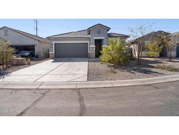 Charming single-story home featuring a two-car garage and desert landscaping at 24134 N Cotton Cir, Florence, AZ 85132