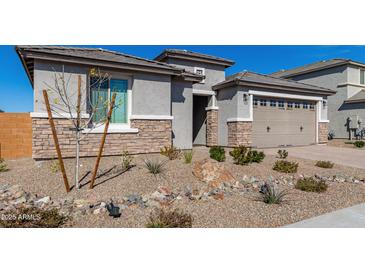 Attractive single-story home featuring a two-car garage and low-maintenance desert landscaping at 25948 W Sands Dr, Buckeye, AZ 85396