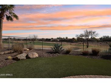 Spacious backyard with golf course view, artificial turf, and rock landscaping at 27379 N Makena Pl, Peoria, AZ 85383