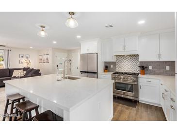 Modern kitchen features white cabinets, stainless steel appliances, and a large island at 8620 E Starlight Way, Scottsdale, AZ 85250