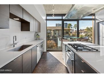 Modern kitchen with stainless steel appliances and ample cabinet space at 100 W Portland St # 401, Phoenix, AZ 85003