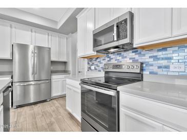 Modern kitchen featuring stainless steel appliances and a gray quartz island at 1959 E Hampton Ln # 102, Gilbert, AZ 85295