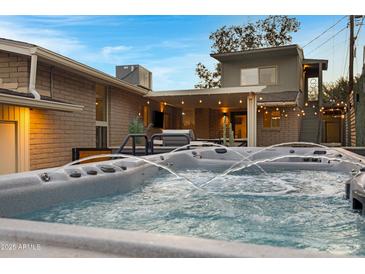 Backyard oasis boasts a modern hot tub, covered patio, and manicured desert landscaping at 2306 N 55Th St, Phoenix, AZ 85008